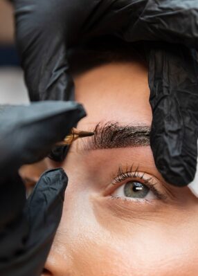 young-woman-getting-beauty-treatment-her-eyebrows young-woman-getting-beauty-treatment-her-eyebrows